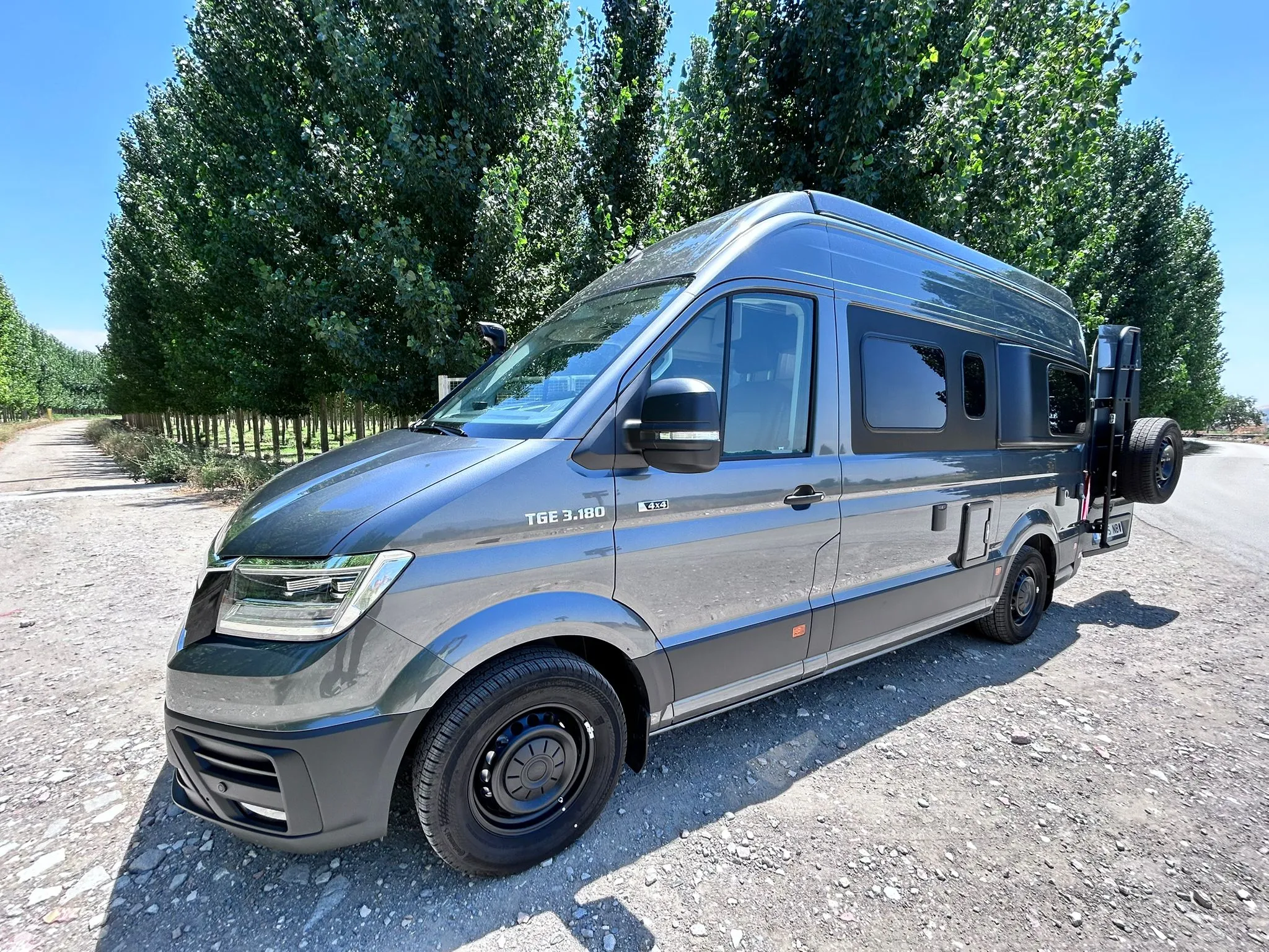 Camper todoterreno gris metalizado con snorkel Bravo, llantas de aleación y toldo Dometic
