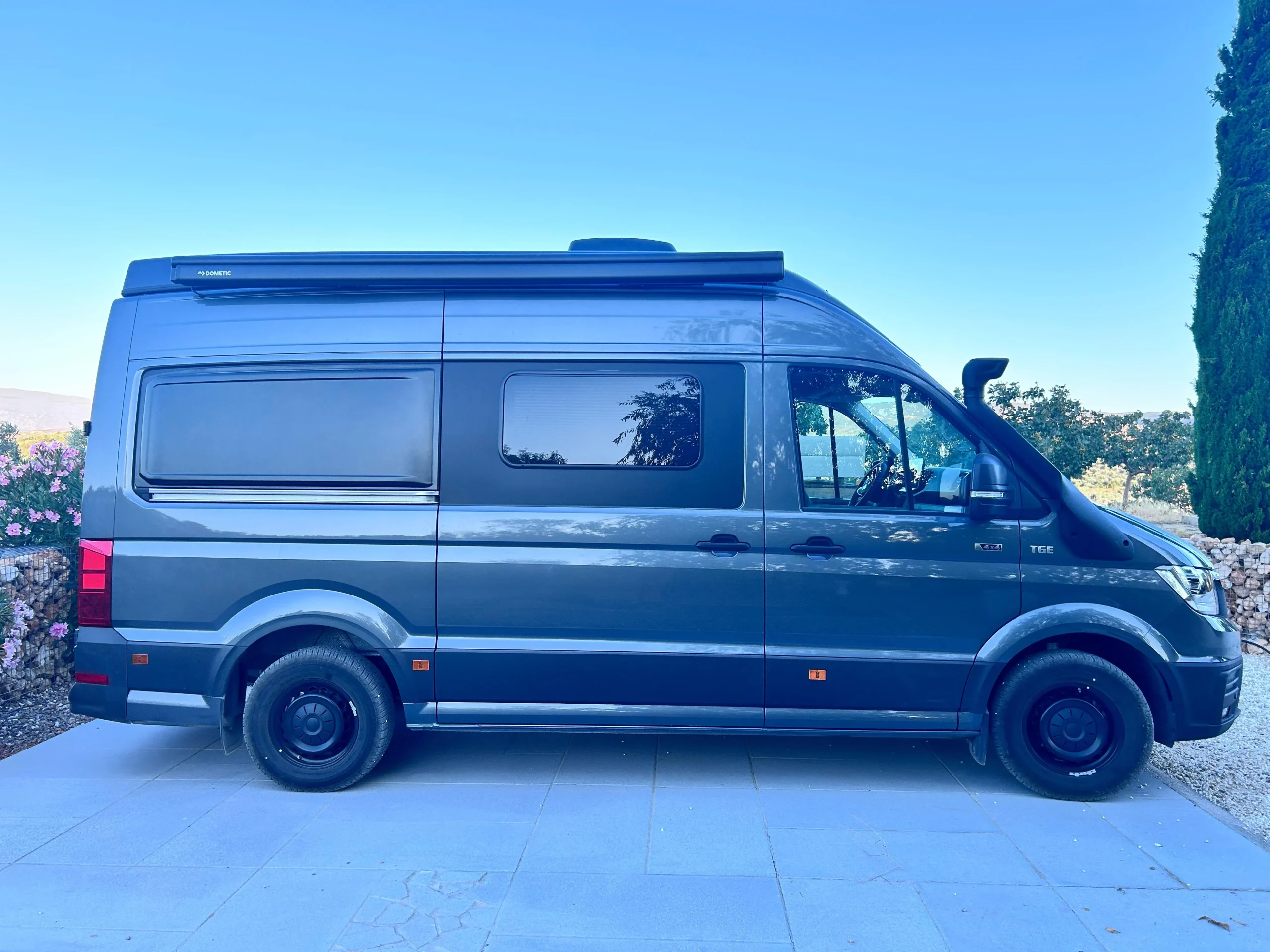 Furgoneta camper MAN TGE 4x4 gris metalizado vista desde el lateral exterior